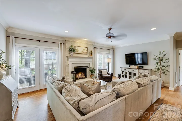 Living room anchored in the center of the home with gas fireplace, this living room has access to the deck, beautiful moldings & hardwoods.