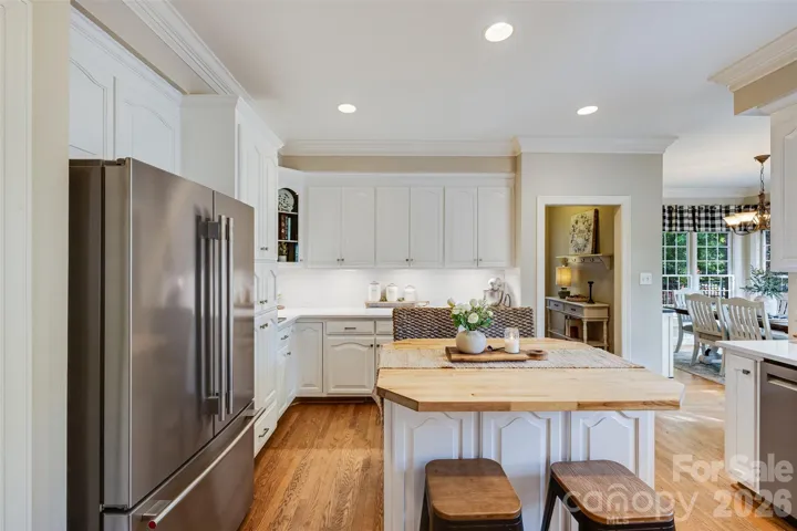 Abundant cabinetry and quartz counters with butcher block island