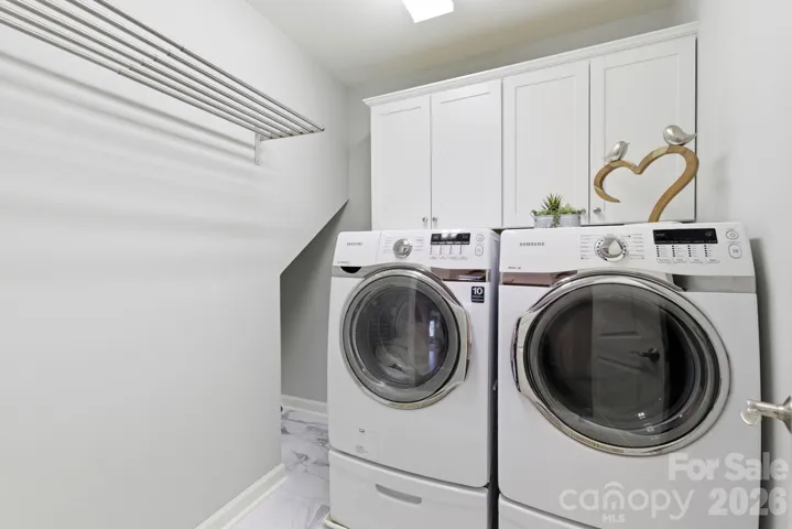 Laundry room with storage cabinets conveniently located upstairs