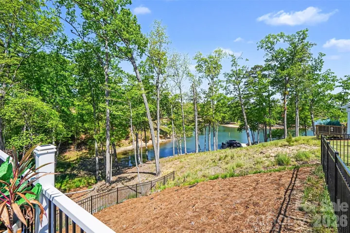 Scenic backyard with year-round water views, offering a peaceful, nature-filled setting surrounded by mature trees.