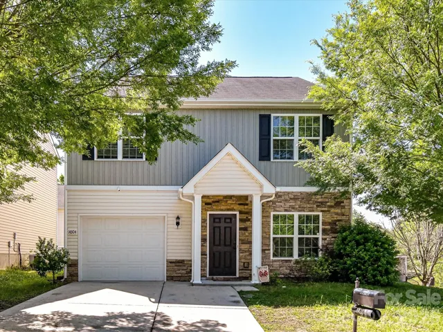 4 bedroom, 2.5 bathroom home in Mallard Lake neighborhood featuring a covered front entry and an attached garage.
