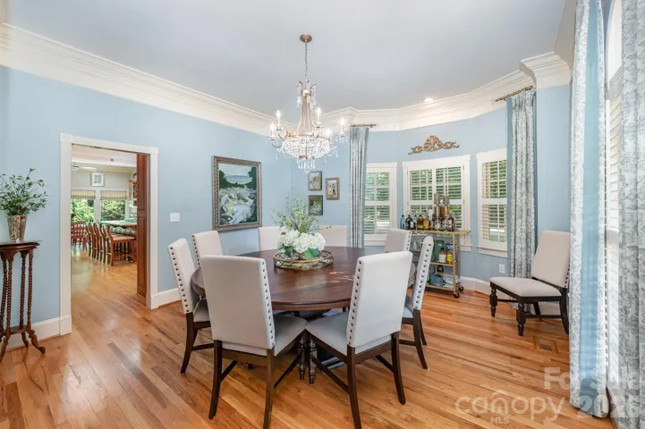 Beautiful wood floors flow into the gorgeous formal dining room with bold crown molding.
