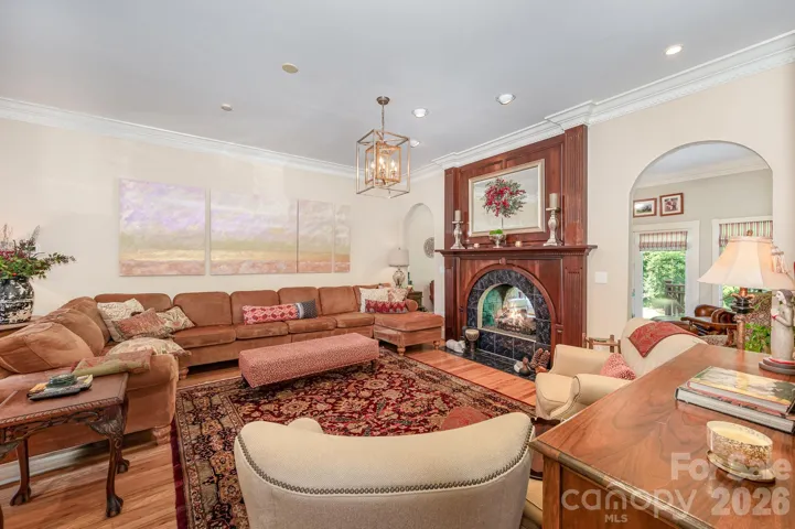Beautiful family room with lovely arched entryways and the other side of the peep-through fireplace