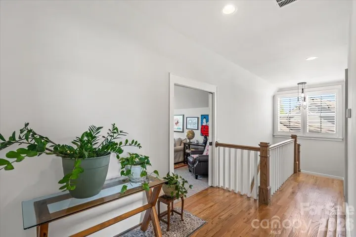 The upper landing is bright, airy, and bathed in light from the picture window.