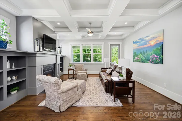 Living room features a coffered ceiling and overlooks the spacious back patio