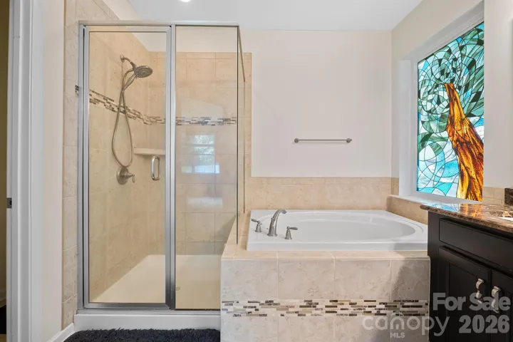Decorative tile tub and shower with gorgeous mosaic tile accents.