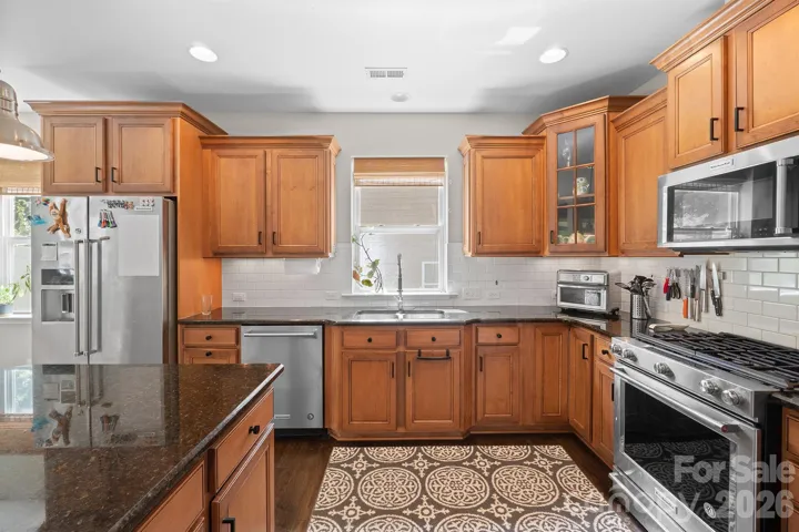 Gourmet Kitchen with Stainless Appliances, Large Island and Subway Tile Backsplash.