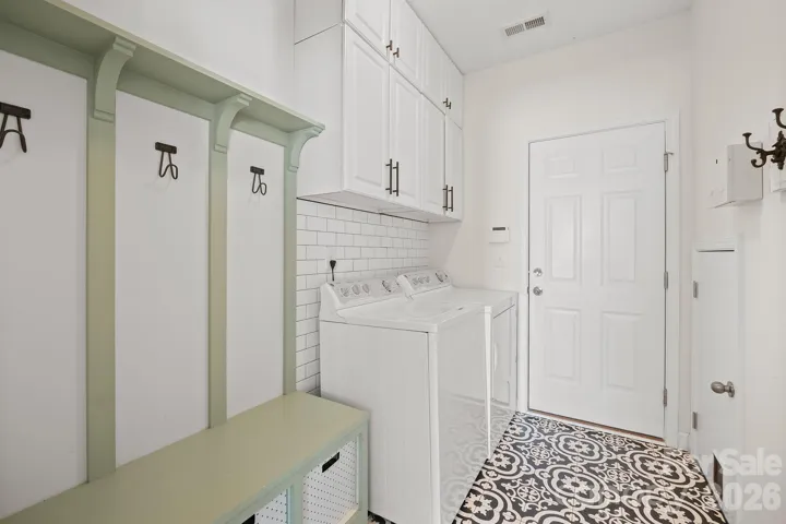 Amazing Laundry with Drop Zone shelving, artisan tile flooring and subway tile accent wall.