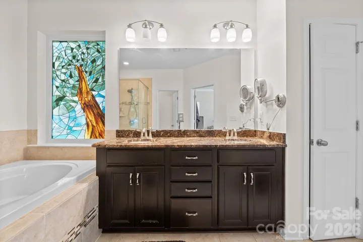 Primary Bath with Granite Dual Vanity and Soaking Tub.