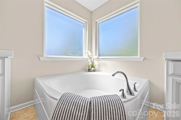 Primary en-suite bathroom w/ double vanities, large garden tub and stall shower