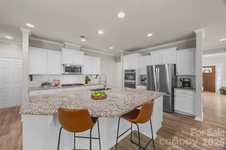 Chef's kitchen w/ SS appliances, granite countertops, double ovens, gas cooktop large island and walk in pantry