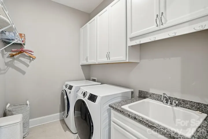 Nice size laundry with cabinets and sink