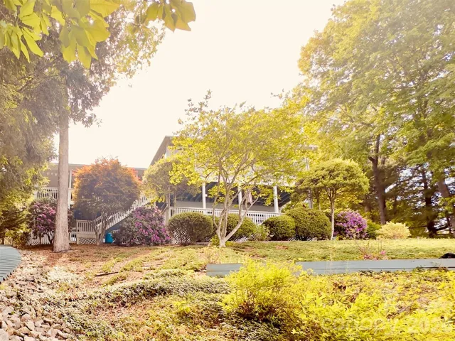 Lake side of property offering beautiful mature landscaping - Lake View of home with upper and lower decks with amazing views