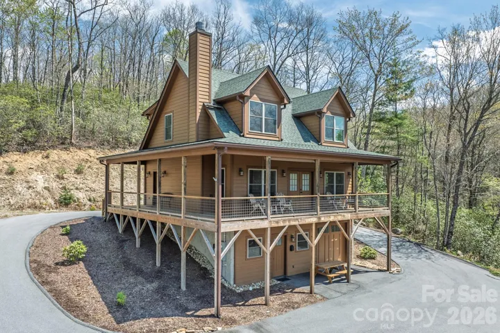 Welcoming exterior view featuring the circular paved driveway, covered front porch, and easy access to the home.
