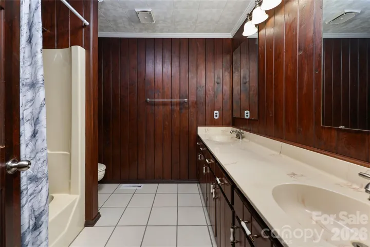 Hall bath with double vanity and tile floors