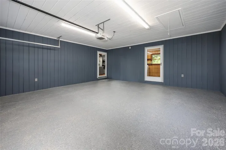 Inside garage with entrance into laundry room and into kitchen