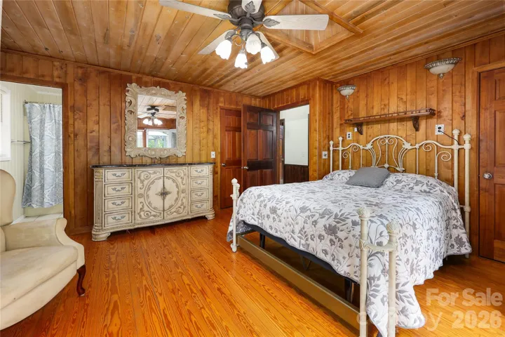 Primary bedroom with hardwood floors and sky light