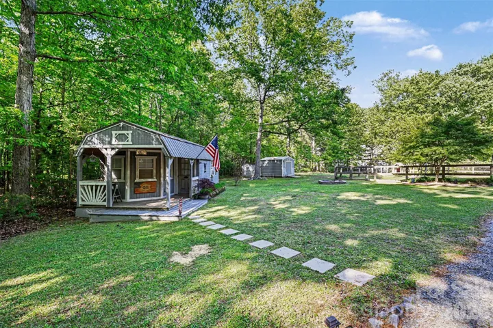 Ideal for hobbyists or extra storage needs, the property includes a wired workshop with covered porch and a rear metal shed with a lean-to.