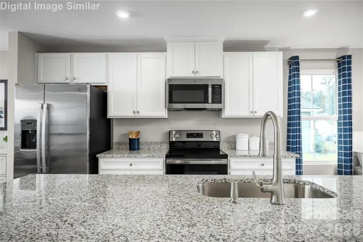 The stainless steel appliances add a sleek, contemporary touch—think professional-grade performance with a polished finish that complements any décor. From the refrigerator to the range, every detail is thoughtfully chosen to elevate your cooking experience.