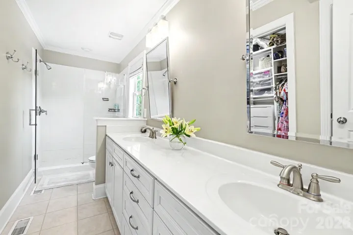 Primary bath with dual vanities and glass enclosed shower