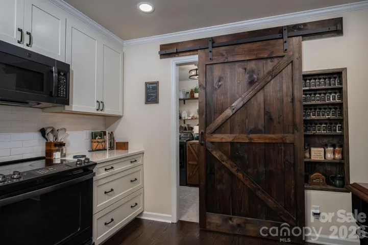 Check out the spice cabinet behind the custom barn door.