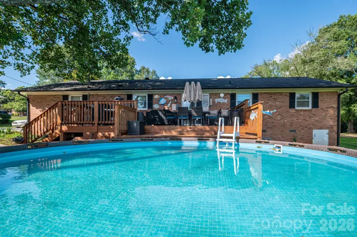 Beautiful above ground pool with deck coming off the rear of home.