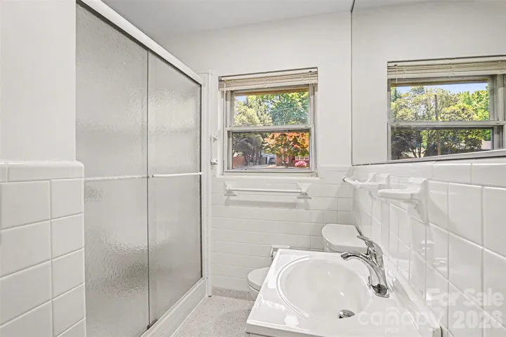 Second full bath, tiled shower with seat and enclosure with privacy glass