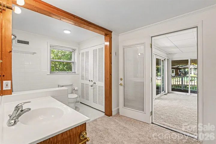 Primary bathroom- updated with carpeted area and bathroom with neutral tile and large jetted tub and linen closet