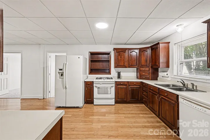 Kitchen cabinets have been replaced, there is a gas stove, bamboo flooring, dishwasher, microwave and refrigerator remain