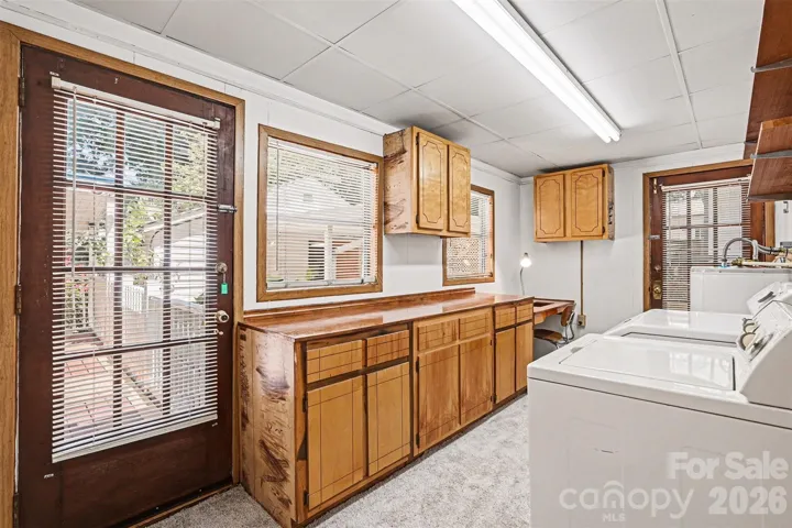 This spacious Laundry/Mud room off the back porch has a driveway exit door as well, hanging area, washer/dryer remain, lots of cabinet space and a built in desk area 