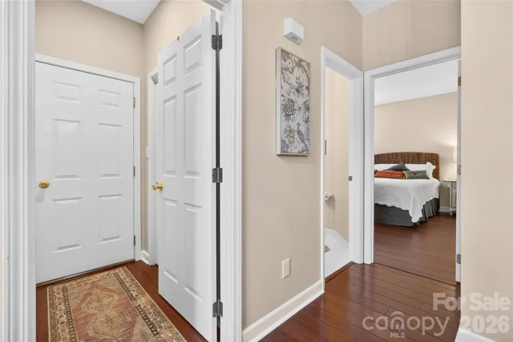 Laundry in hall with rug, garage through the door. Primary bed and powder room