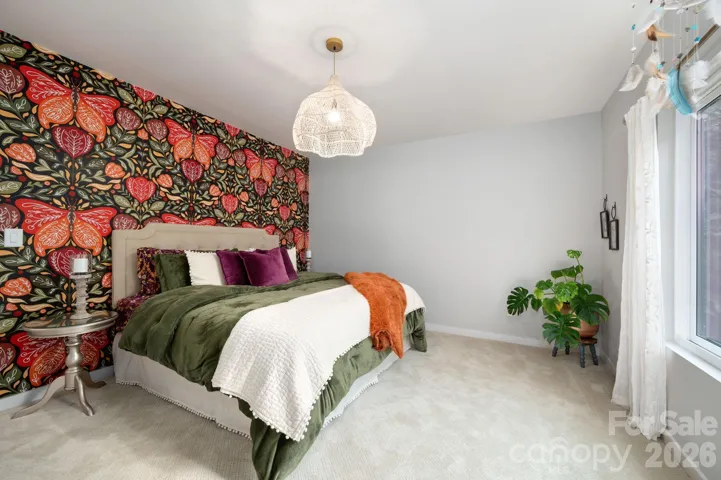 Vibrant guest bedroom with statement wallpaper, plush carpeting.