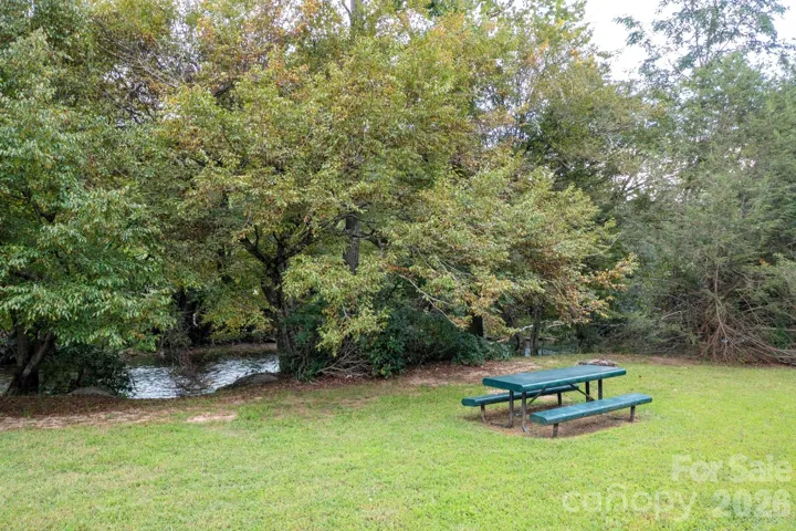 Shaded picnic tables along the river, perfect for relaxing.