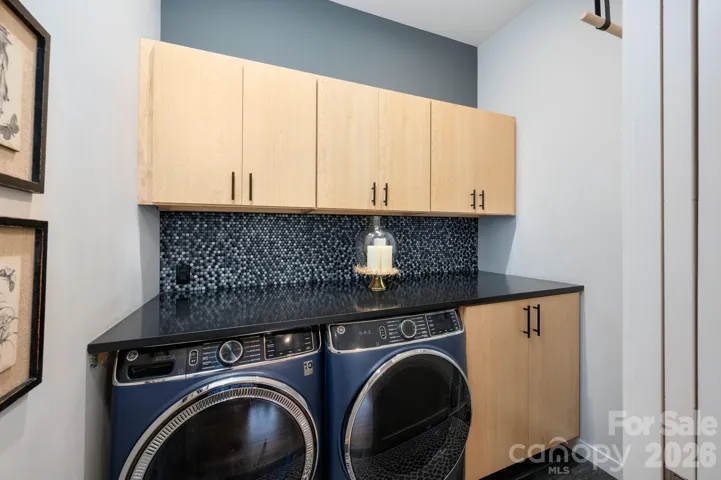 Well-designed laundry with abundant cabinetry, folding counter.