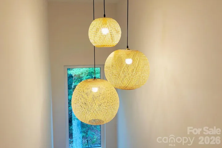 Modern boho pendants illuminate the stairwell with style and warmth.