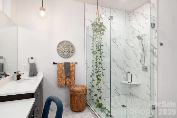 Spa-like bath with frameless glass shower, elegant tilework, and modern finishes.