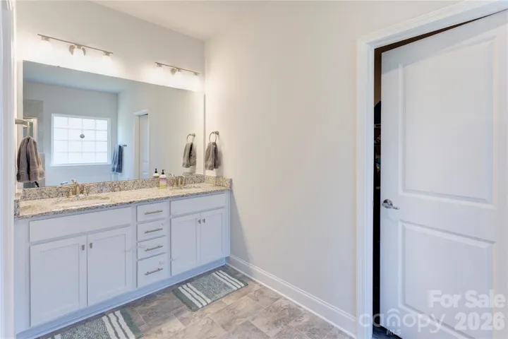 Spacious primary bath has double vanities and a walk-in closet