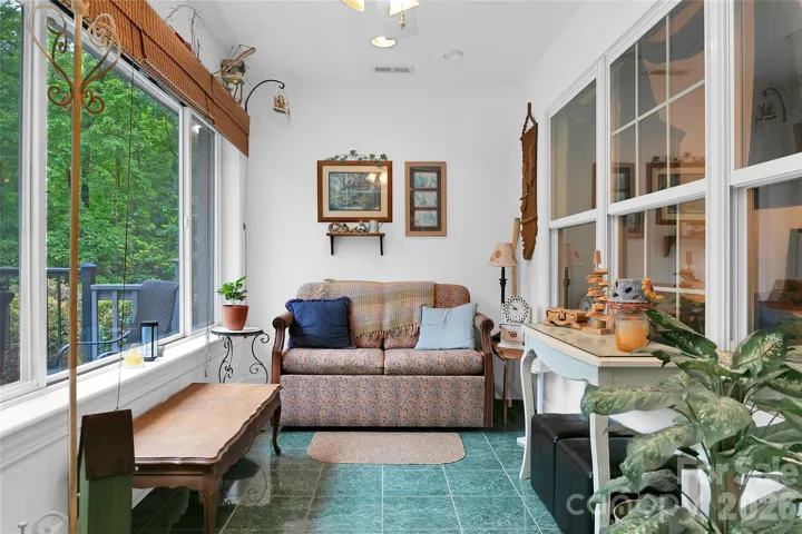 The sunroom is sunny and bright, and by opening the interior windows to the adjacent living room, the space for entertaining grows.