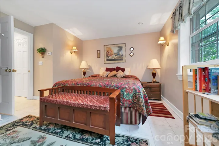 The primary suite bedroom is an ample room with windows looking out to the front and side yards.