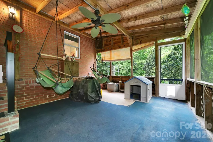 The screen porch in the back leads out to the lower patio by the woods.
