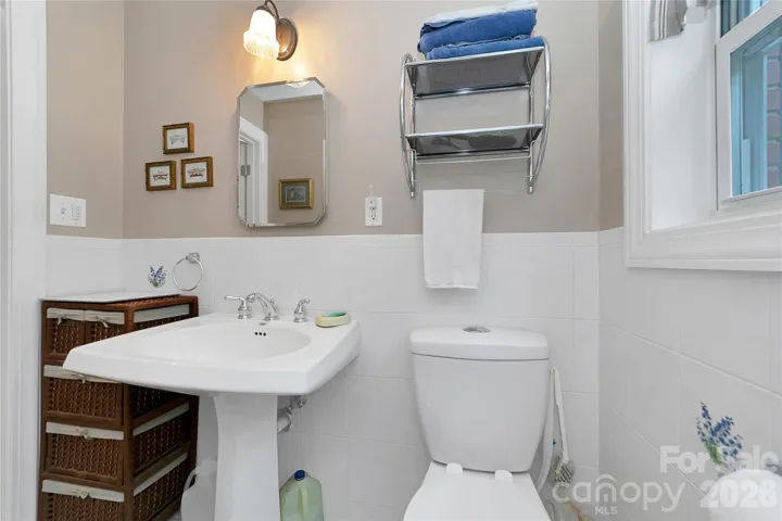 The primary suite bathroom is white, light and bright.