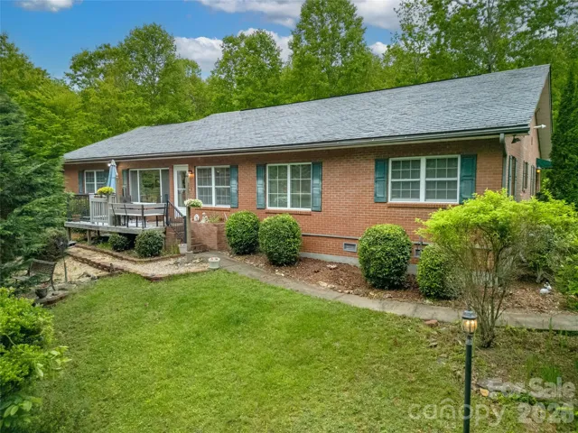 The nice level walkway from the garage side to the front deck, also leads to the front garden area over a small bridge. Very serene and private setting.!