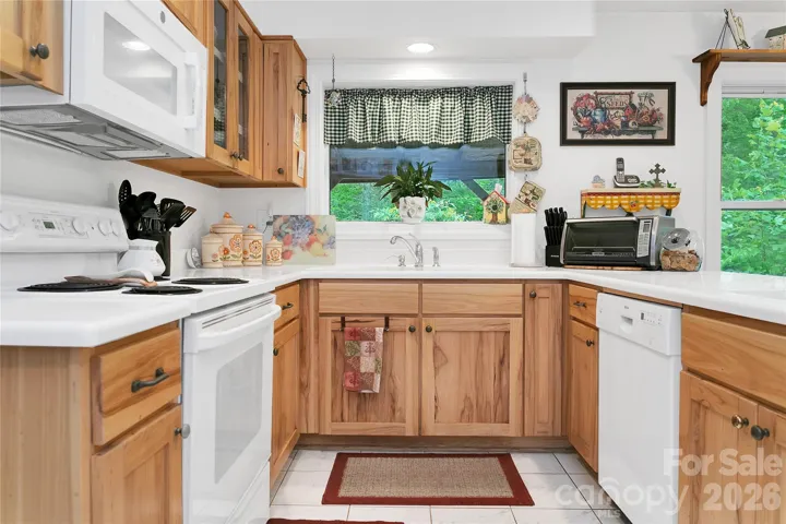 The kitchen has a beautiful white Corian countertop, complimented by white appliances throughout. The cabinets are abundant and really work with the white.
