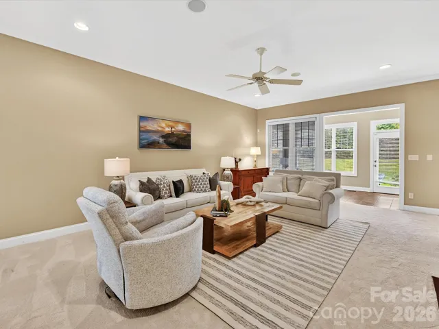 Spacious great room featuring a cozy fireplace, abundant natural light, and an open layout that seamlessly connects to the kitchen and dining areas—perfect for everyday living and entertaining.