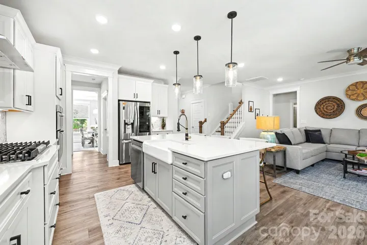 Gorgeous kitchen with gas cooktop, large island with farmhouse style sink and quartzite countertops
