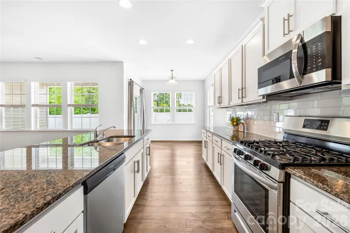 Dream kitchen has gas range, granite and tile backsplash. Microwave vents to exterior.