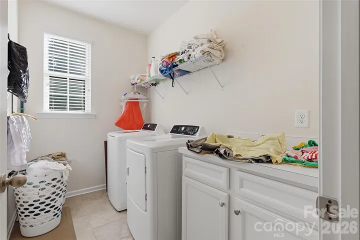 Cheerful and large laundry on main with folding counter and storage