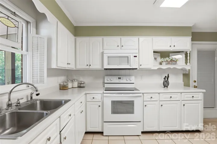 View of kitchen with display shelf and microblind glass door leading into garage