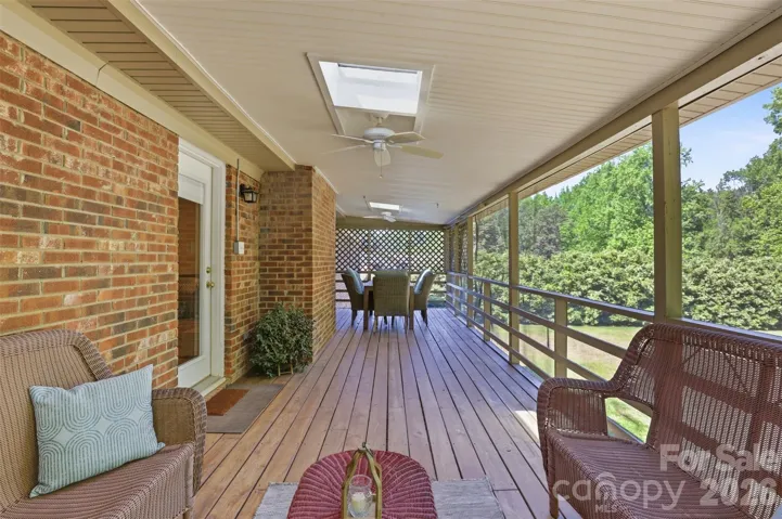 This massive rear porch is the perfect space for entertaining, surrounded by nature!