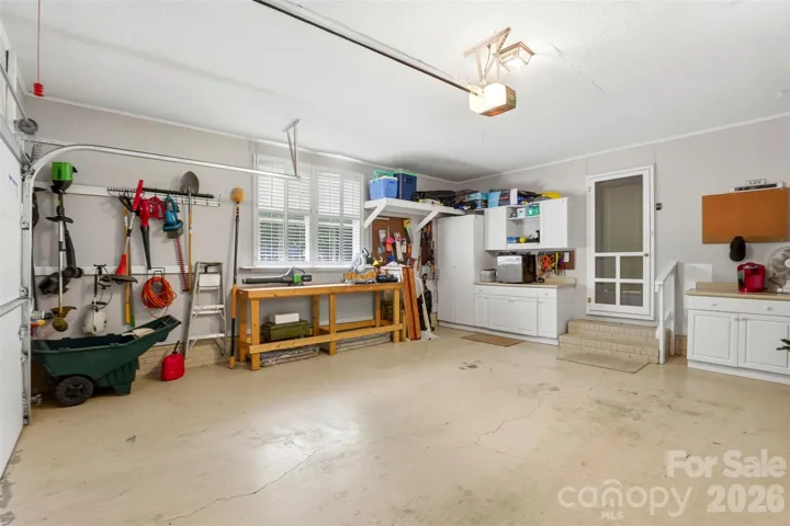 Intereior of the side loading garage boasts lots of storage and natural light. There is also a secondary laundry hookup in this area.